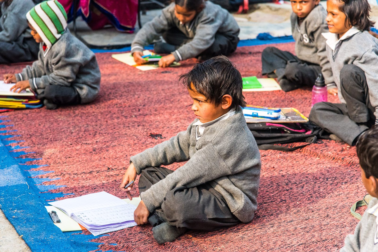 A young student writing in his notebook during a One Life At A Time class