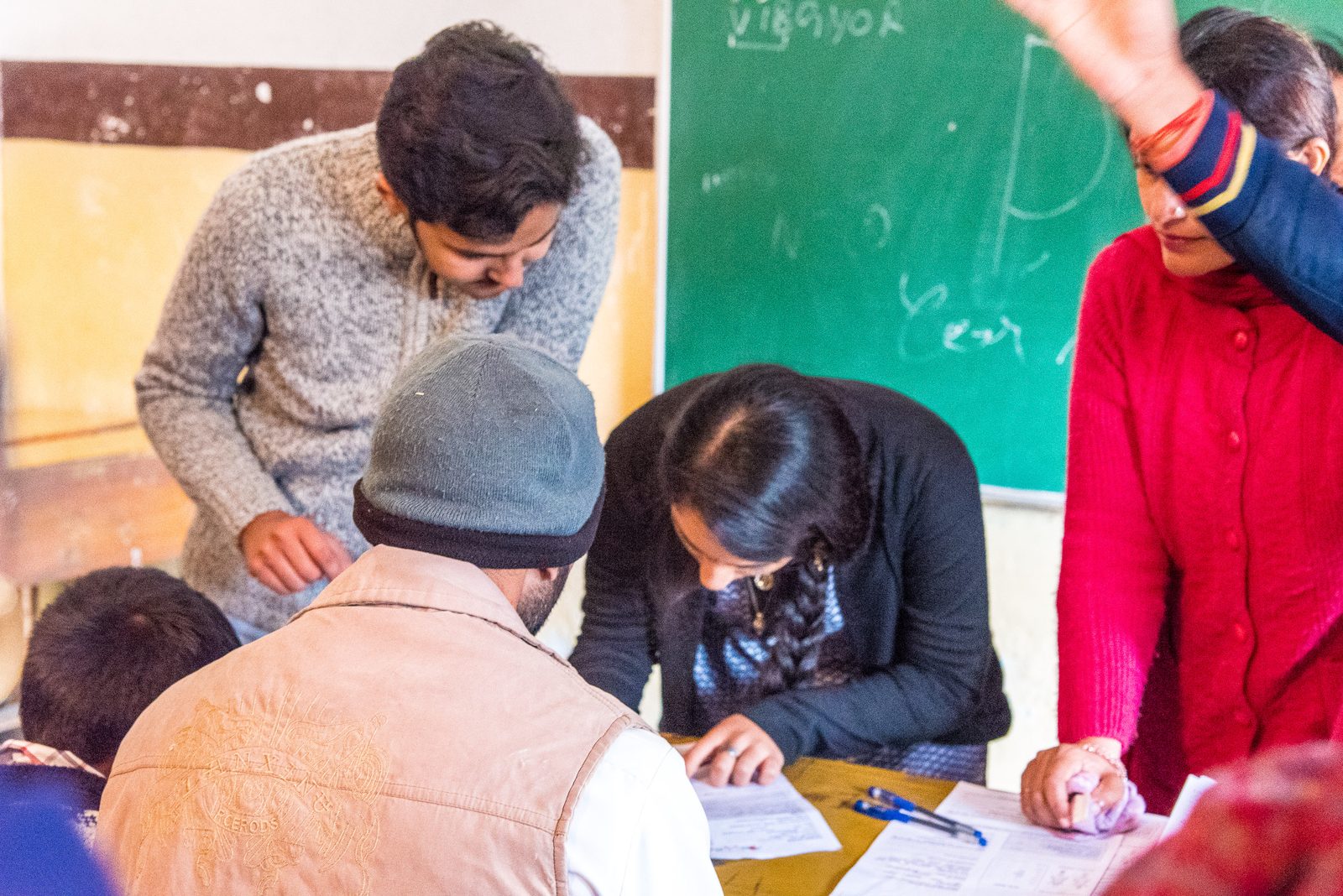 Volunteers helping villagers complete medical forms