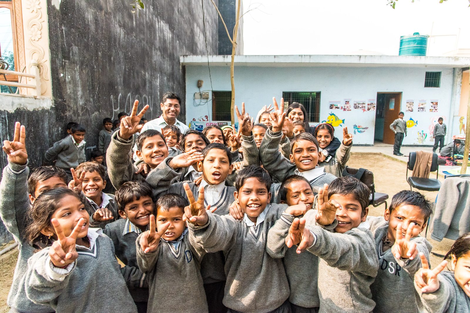 Students smiling and flashing peace signs at a One Life At A Time school