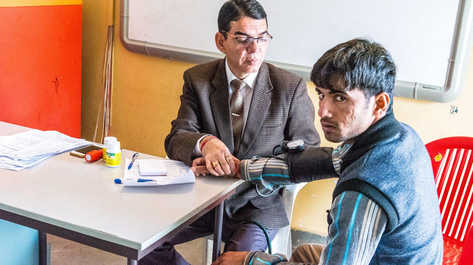 A doctor checking a patient's blood pressure at a rural medical camp